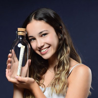 Girl holding message in bottle