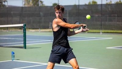 Young man hitting tennis forehand