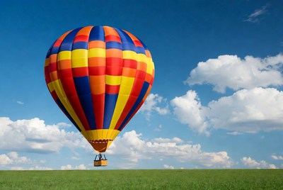 Colorful hot air balloon over green field