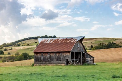 Rustic red barn in rolling hills