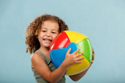 Happy girl holding colorful beach ball