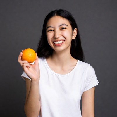 Asian girl holding orange smiling