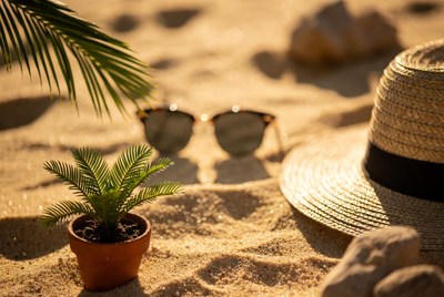 Sunglasses and straw hat on beach