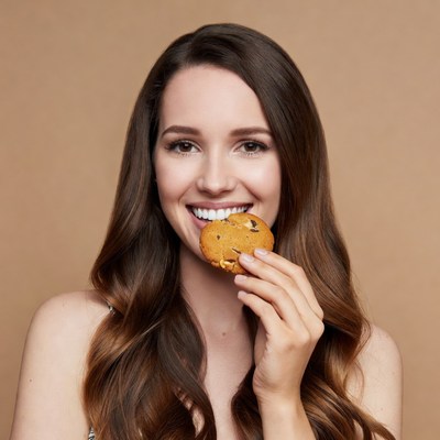 Woman biting chocolate chip cookie