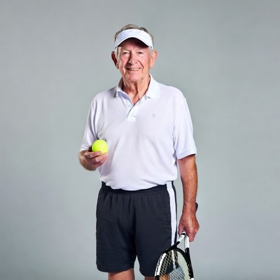 Elderly man holding tennis ball and racket