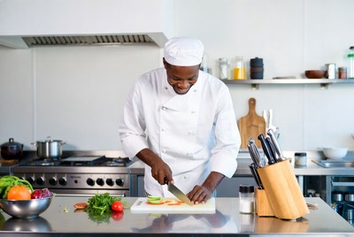 African-American chef slicing vegetables