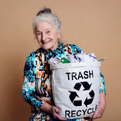 Elderly woman holding trash recycle bin