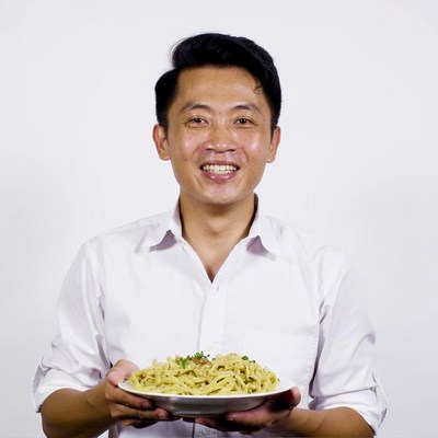 Asian man holding pasta dish