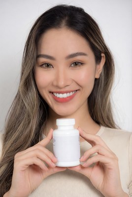 Asian woman holding supplement bottle