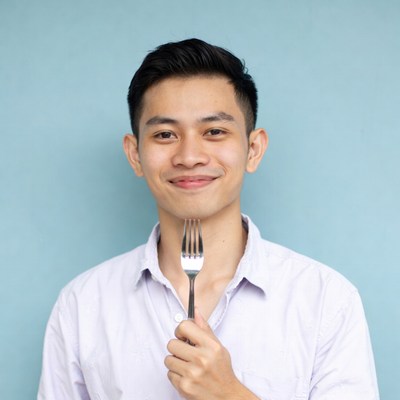 Asian man holding fork