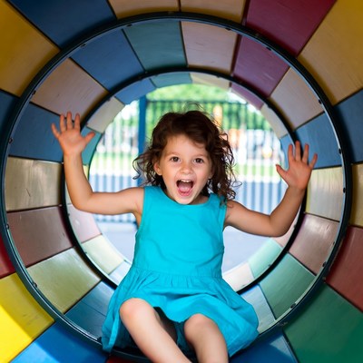Girl smiling in colorful tunnel playground