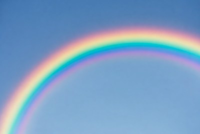 Vibrant rainbow in blue sky