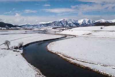 Snowy River Winding Through Winter Mountains