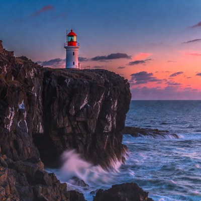 Red Lighthouse on Cliff at Sunset