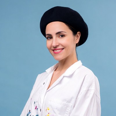 Woman in black beret and paint-splattered shirt