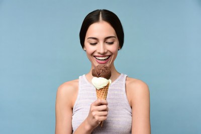 Woman eating chocolate vanilla ice cream cone