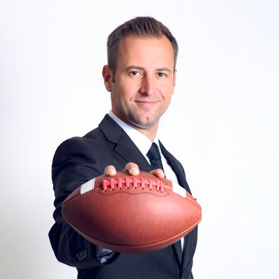Man in suit holding football