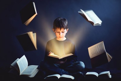 Boy reading with flying books
