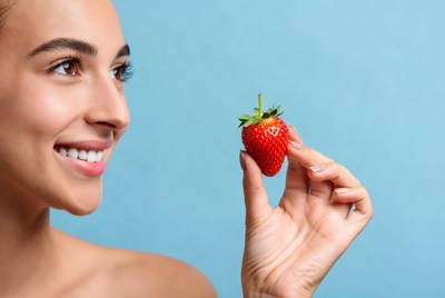 Woman holding fresh strawberry