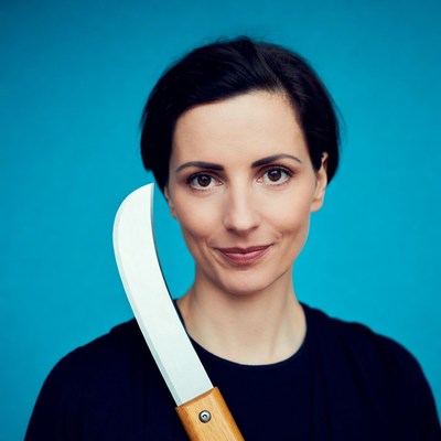 Woman holding machete on blue background