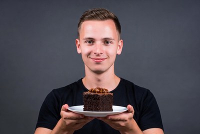 Young man holding chocolate cake