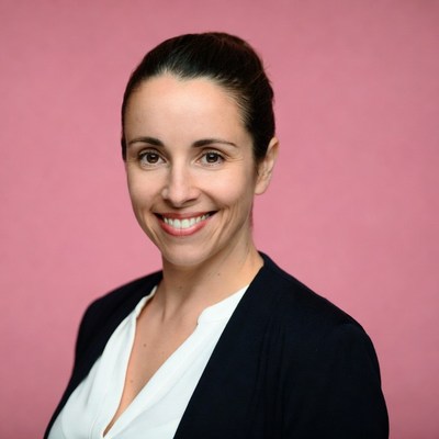 Smiling woman in blazer on pink background