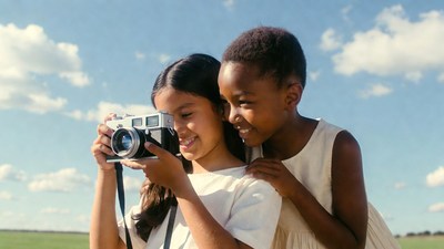 Two girls holding vintage camera outdoors