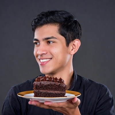 Young man holding chocolate cake