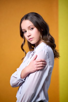 Teen girl arms crossed orange background