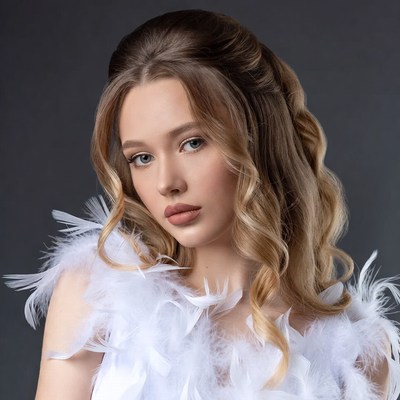Woman with feathered shoulders and wavy hair