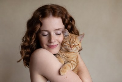 Woman hugging orange kitten