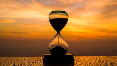Hourglass with sand against sunset
