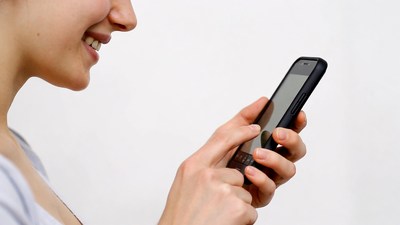 Asian woman smiling at smartphone