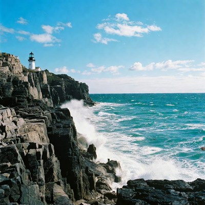 Lighthouse on rocky cliffs with crashing waves