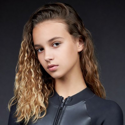 Teen girl with wavy hair in black wetsuit