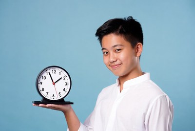 Asian boy holding white clock