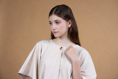 Young woman in beige batwing dress