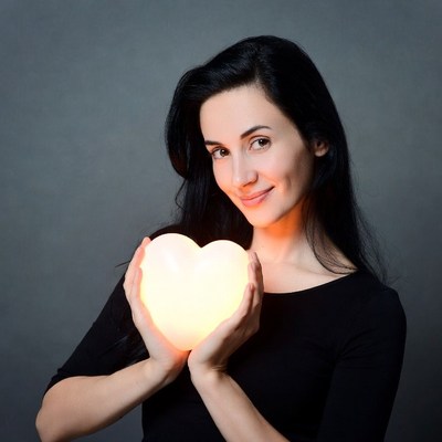 Woman holding glowing heart