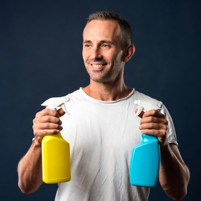 Man holding yellow and blue spray bottles