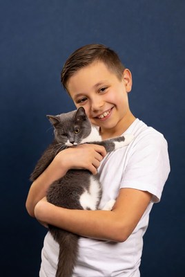 Boy hugging gray cat