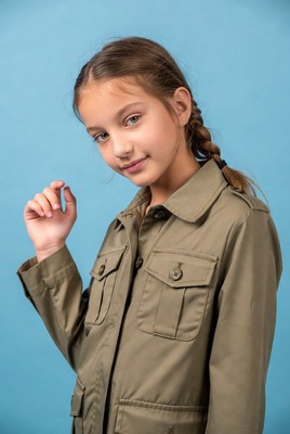 Girl in khaki jacket on blue background