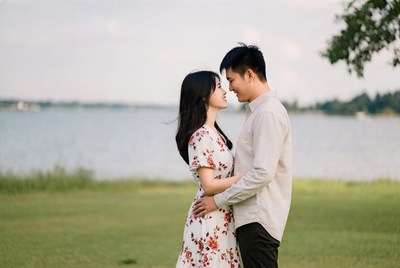 Asian couple embracing by lake