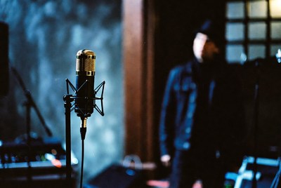 Man behind vintage microphone in studio