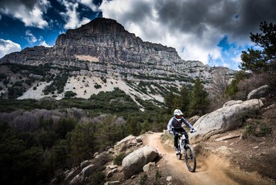 Woman mountain biking rocky trail