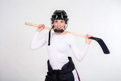 Woman holding hockey stick and helmet