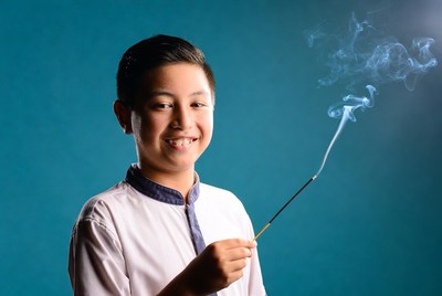 Asian boy holding incense stick