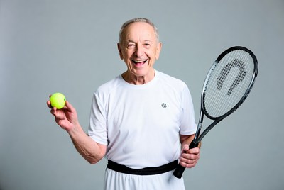 Smiling senior man holding tennis racket and ball