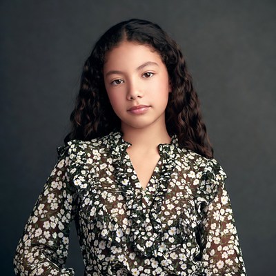 Curly-haired girl in floral blouse