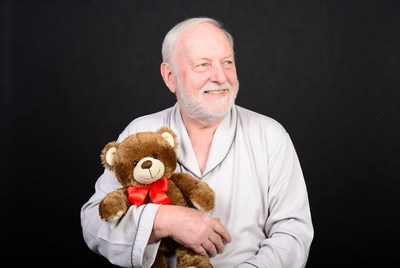 Elderly man holding teddy bear