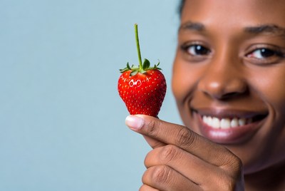 African-American woman holding strawberry